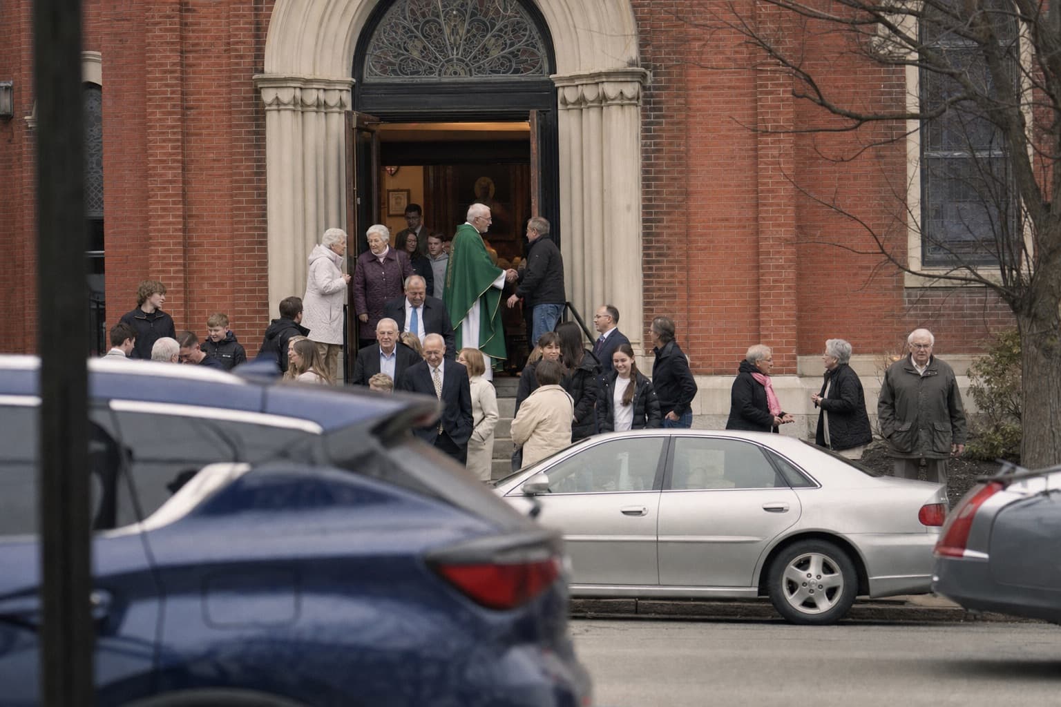 Parishioners on the steps of a brick church after Mass